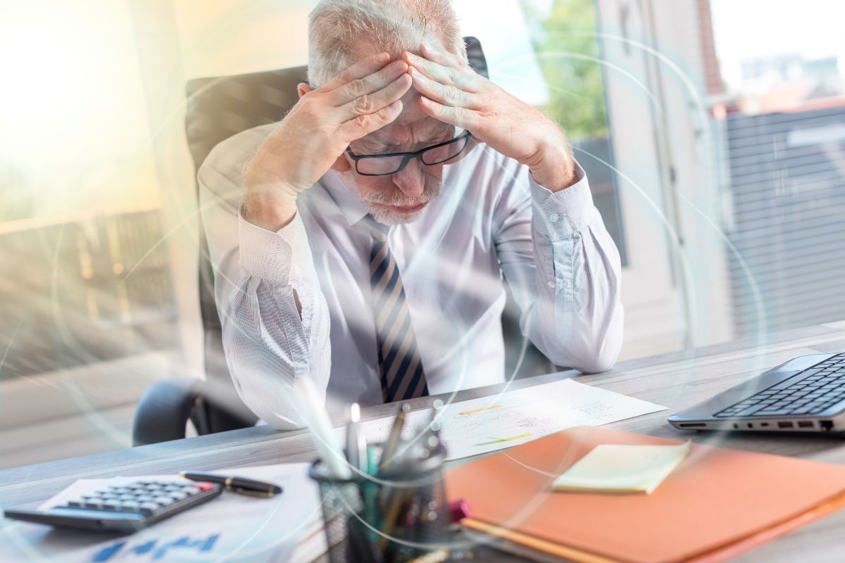 Stresszes férfi munka közben, a stressz hatása a szervezetre és a túlélő üzemmód szemléltetésére.
